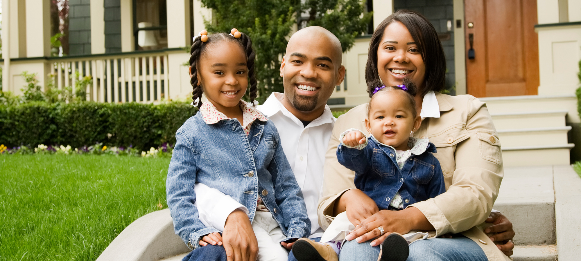 Parents posing with two children smiling 